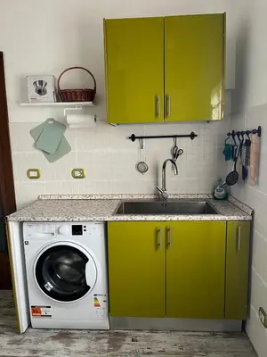 a kitchen with green cabinets and a washing machine at Casa Valle dei Casali near St Peters Basilica in Rome