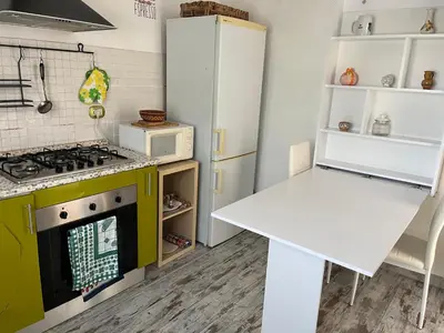 a kitchen with a stove and a white refrigerator at Casa Valle dei Casali near St Peters Basilica in Rome