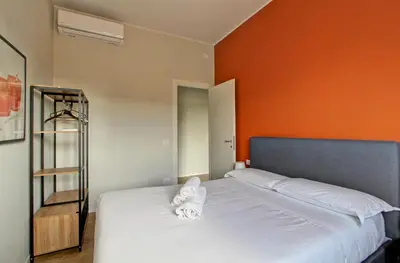 a bedroom with a bed with an orange wall at Design Monteverde Flat Jenner 70 in Rome