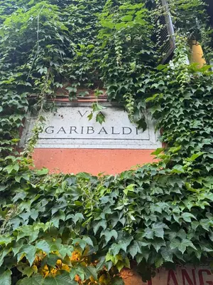 a sign obscured by plants on a building at Garibaldi Studio Apt in Rome