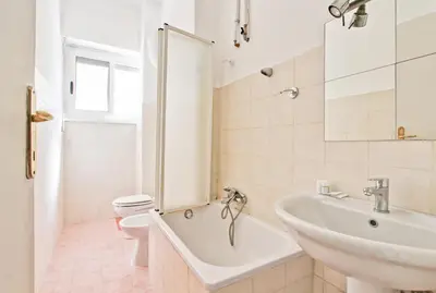 a bathroom with a tub and a sink and a toilet at White Boutique Apartment in Rome