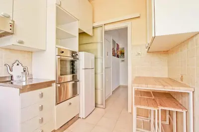 a kitchen with white cabinets and a refrigerator at White Boutique Apartment in Rome