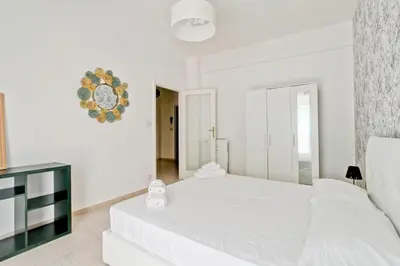 a white bedroom with a white bed and a mirror at White Boutique Apartment in Rome