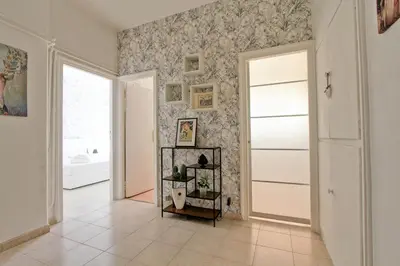 a hallway with a white door and a tile floor at White Boutique Apartment in Rome
