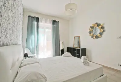 a white bedroom with a bed and a window at White Boutique Apartment in Rome