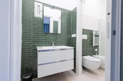 a bathroom with a sink and a toilet and green tiles at Rose of pyramid in Rome