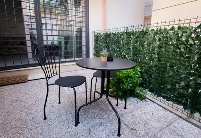 a table and two chairs in front of a green hedge at Rose of pyramid in Rome
