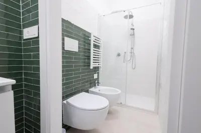 a bathroom with a toilet and a shower with green tiles at Rose of pyramid in Rome