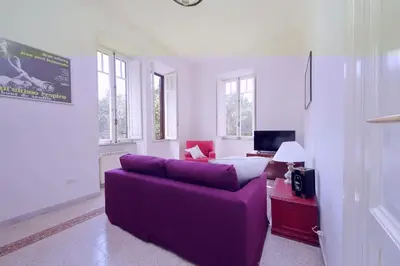 a living room with a purple couch and a bed at Carlo Felice in Rome