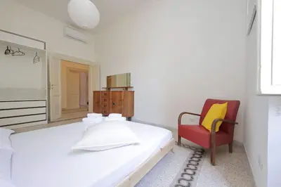 a bedroom with a large bed and a red chair at Carlo Felice in Rome