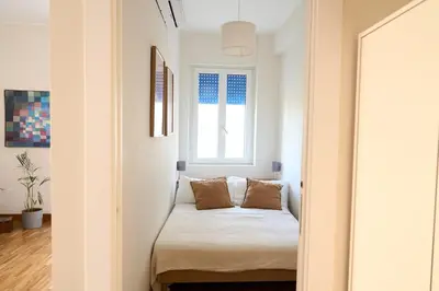 a small bedroom with a bed and a window at Cozy Pigneto Flat with Balcony in Rome