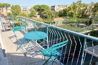 two chairs and a table on a balcony with a tennis court at Cozy Pigneto Flat with Balcony in Rome