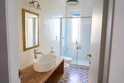 a bathroom with a sink and a toilet and a mirror at Cozy Pigneto Flat with Balcony in Rome