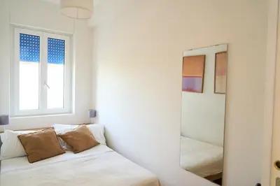 a white bedroom with a mirror and a bed at Cozy Pigneto Flat with Balcony in Rome