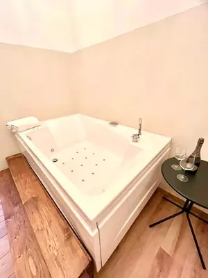 a large white bath tub in a room with a table at Pantheon Luxury Jacuzzi Apartment in Rome