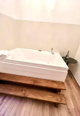 a white tub in a bathroom with a wooden floor at Pantheon Luxury Jacuzzi Apartment in Rome