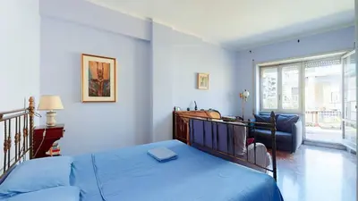 a bedroom with blue walls and a bed with a blue blanket at FIORELLA's TERRACE in Rome