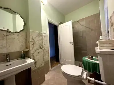 a bathroom with a sink and a toilet and a mirror at FIORELLA's TERRACE in Rome