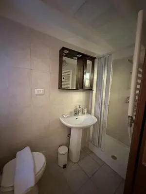 a bathroom with a sink and a toilet and a mirror at Arco Acetari - The Middle Ages in the heart of Rome in Rome