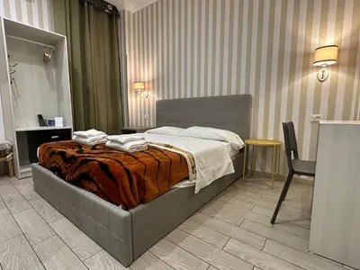 a bedroom with a bed and a table and a chair at SUNSHINE ROOMS 1s in Rome