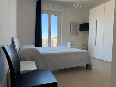 a bedroom with a bed and a chair and a window at Home in Roma in Rome