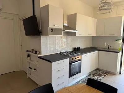 a kitchen with white cabinets and a stove top oven at Home in Roma in Rome