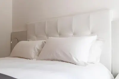a white bed with white sheets and pillows at Chessa's Rooms in Rome