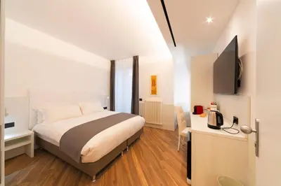 a bedroom with a bed and a desk and a television at Chessa's Rooms in Rome