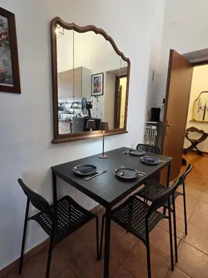 a dining room table with chairs and a mirror at Casa Guardini in Rome in Rome