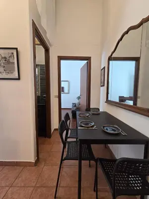 a dining room with a table and chairs and a mirror at Casa Guardini in Rome in Rome