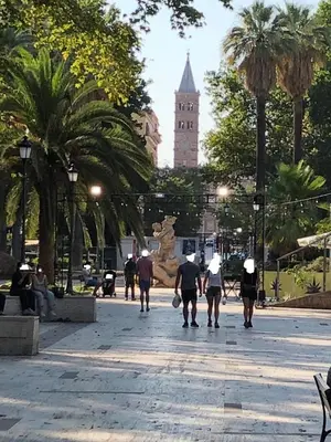 a group of people walking down a street with a clock tower at Casa Guardini in Rome in Rome