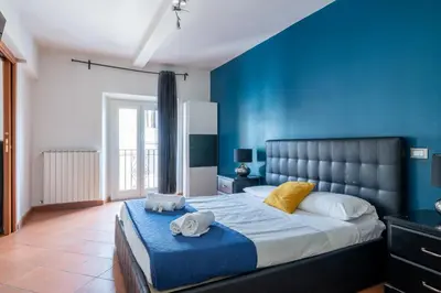 a bedroom with a large bed with blue walls at Casa Vacanza trastevere in Rome