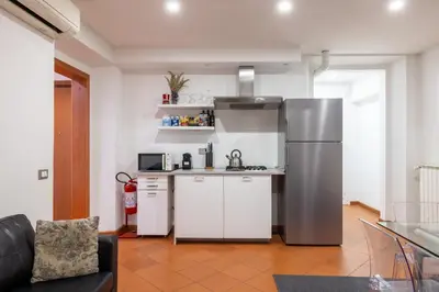 a kitchen with a stainless steel refrigerator and white cabinets at Casa Vacanza trastevere in Rome