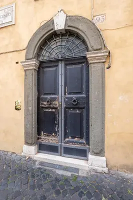 a large black door in the side of a building at Casa Vacanza trastevere in Rome
