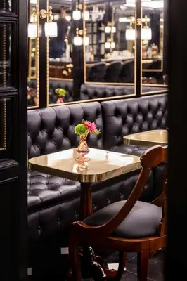 a table and chair with a vase of flowers on it at Hotel d’Inghilterra Roma – Starhotels Collezione in Rome