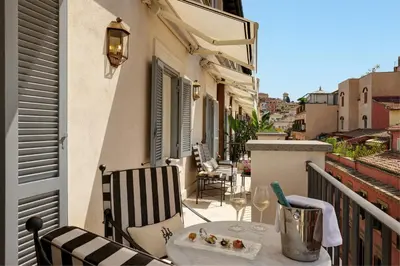 a balcony with a table and chairs on a balcony at Hotel d’Inghilterra Roma – Starhotels Collezione in Rome