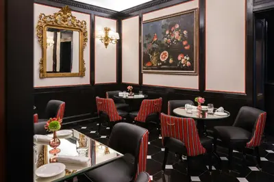 a restaurant with two tables and chairs and a mirror at Hotel d’Inghilterra Roma – Starhotels Collezione in Rome
