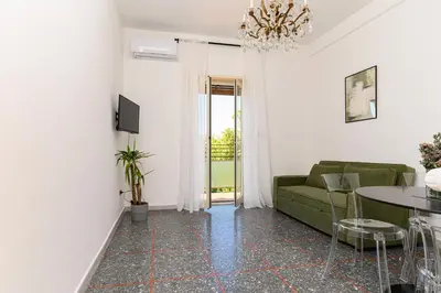 a living room with a green couch and a table at NEW Diana's place with terrace San Pietro Station in Rome