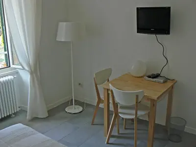 a room with a table and a television and a bed at B&b Il Sampietrino Dei Cavalleggeri in Rome
