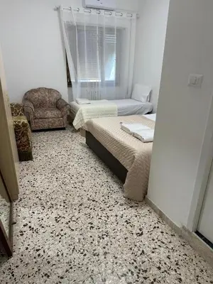 a bedroom with two beds and a chair at Roma Guest house Aversa 55 in Rome
