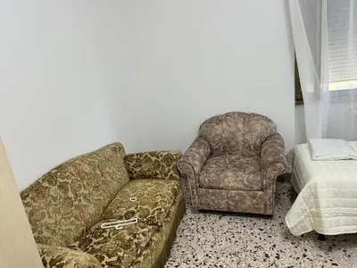 a living room with a couch and a chair at Roma Guest house Aversa 55 in Rome
