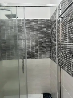 a shower with a glass door in a bathroom at Roma Guest house Aversa 55 in Rome