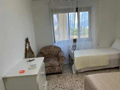 a bedroom with a bed and a chair and a window at Roma Guest house Aversa 55 in Rome