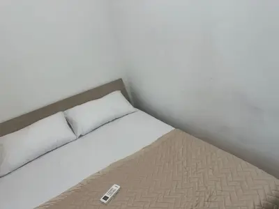a bed in a room with a remote control on it at Roma Guest house Aversa 55 in Rome
