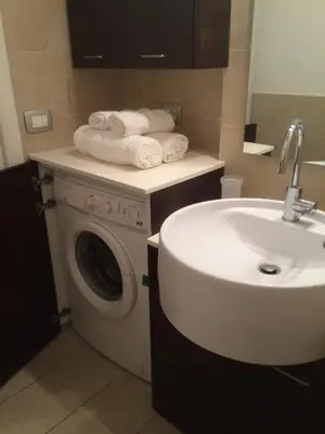 a bathroom with a washing machine and a sink at Chat&Chill Vatican Apartment in Rome