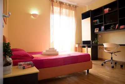 a bedroom with a bed and a window and a desk at Chat&Chill Vatican Apartment in Rome