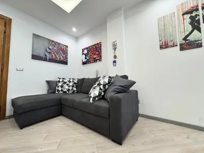 a living room with a black couch and some pictures at Banksy Urban Suite in Rome