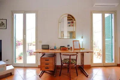 a room with a desk with two chairs and a table at Elegantis Monti Penthouse With Private Terrace and Colosseum View in Rome