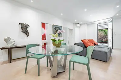a living room with a glass table and chairs at Skylife Garden of Olives in Rome