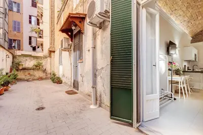 an alley in an old building with a green door at Vatican Scipioni Charming Studio relaxing and patio in Rome